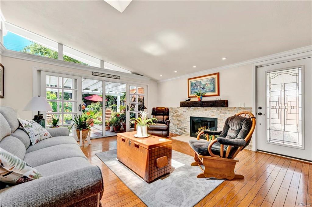 12231 Wilken Way — light-filled living room with vaulted ceiling and wood floors