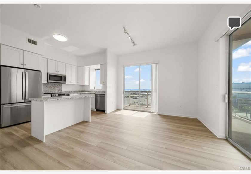 488 E Ocean Blvd #717 — open living room and kitchen with ocean views through floor-to-ceiling sliders
