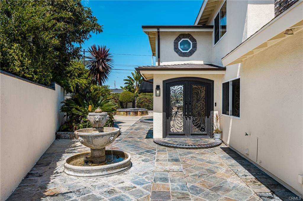 2342 Cynthia Ct — gated courtyard entry with stone paving and tranquil fountain