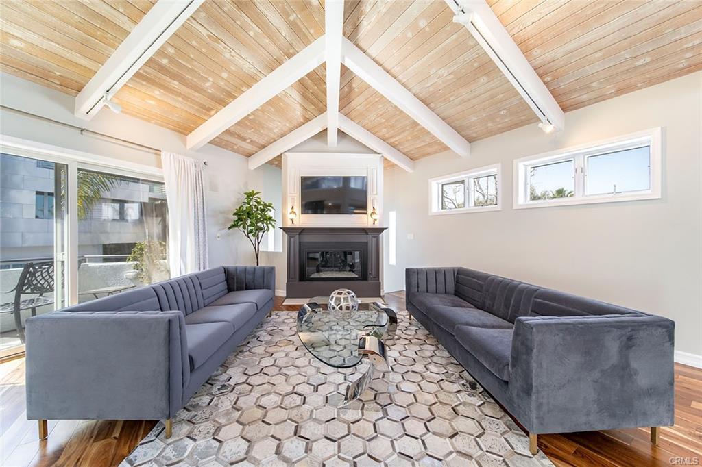 6063 Lido Ln — living room with beamed cathedral ceilings and fireplace