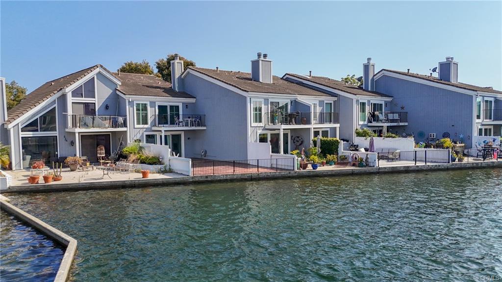 3631 Windspun Dr — waterfront rear elevation with balconies overlooking the lagoon