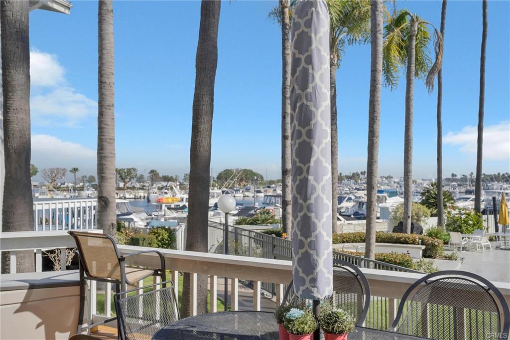 16276 Pacific Cir #B — front deck with seating and marina views through the palms