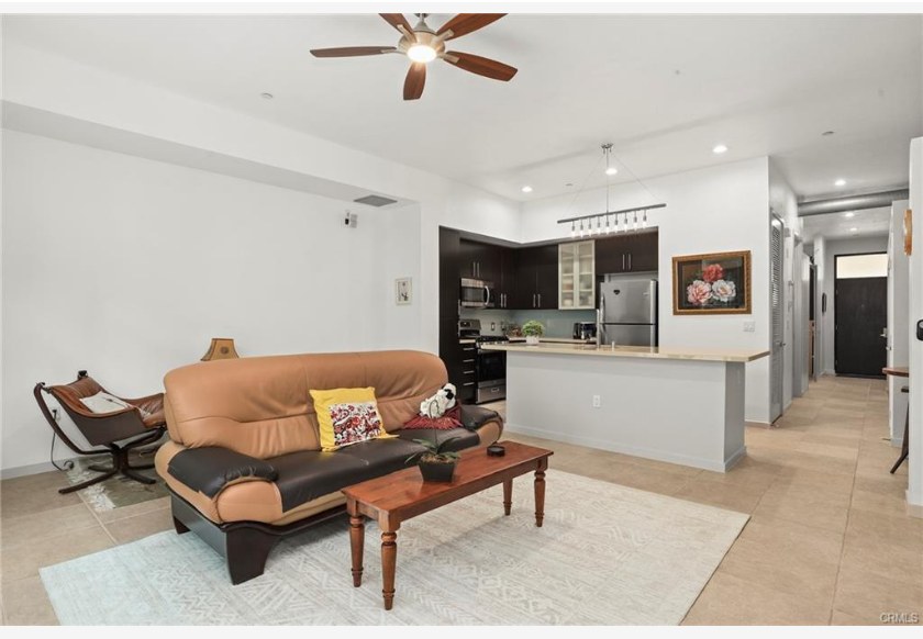 133 The Promenade N #318 — open living room with tile flooring and exposed ducts
