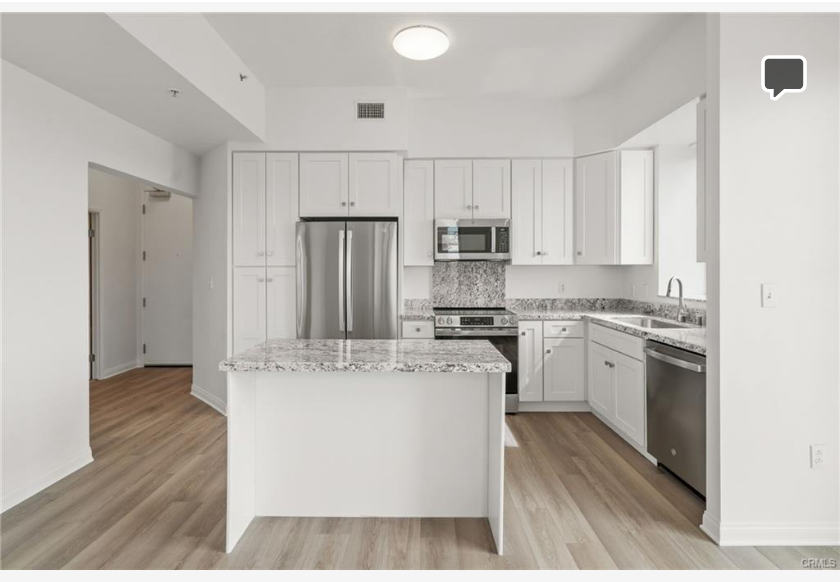 488 E Ocean Blvd #717 — remodeled kitchen with shaker cabinets, granite counters, and stainless appliances