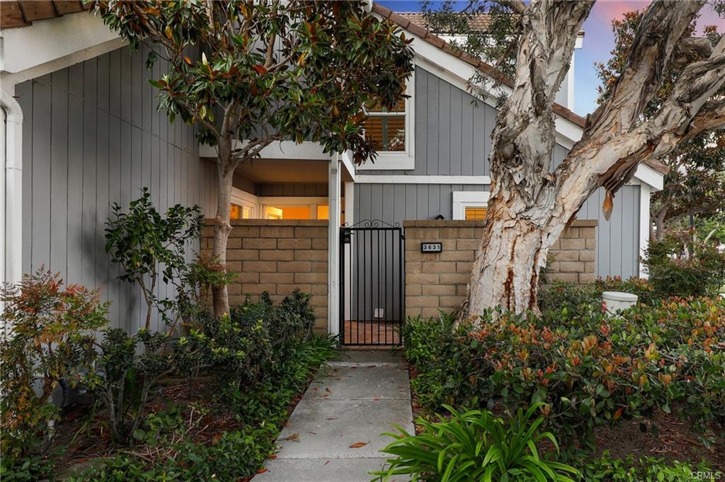 3631 Windspun Dr — gated front courtyard entry framed by mature eucalyptus