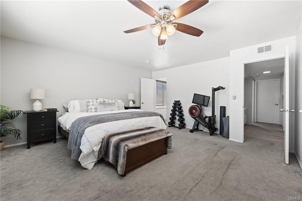 18126 Sand Dunes Ct — spacious primary suite with ceiling fan and dual walk-in closets