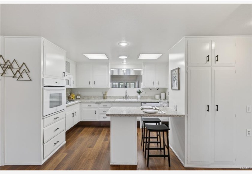 1200 Canoe Brook Dr #19D — updated kitchen with granite peninsula, white cabinetry, and bar seating