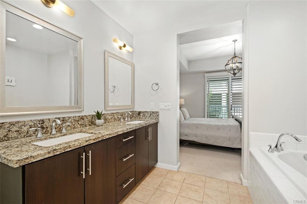 21 Gramercy #202 — primary bath with dual sinks and upgraded tile