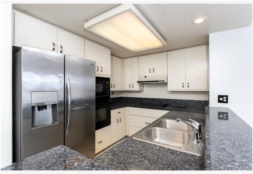 700 E Ocean Blvd #2308 — kitchen with stainless refrigerator, granite counters, and ample cabinetry