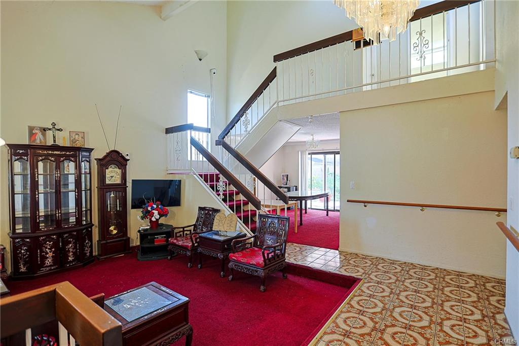 17031 Ward St — open living and dining area with staircase and tall windows