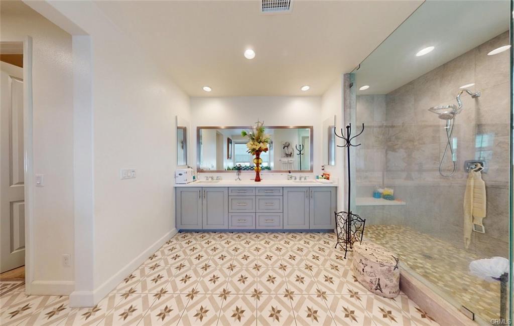 12954 Dahlia St — spa-like primary bath with dual vanities and oversized shower