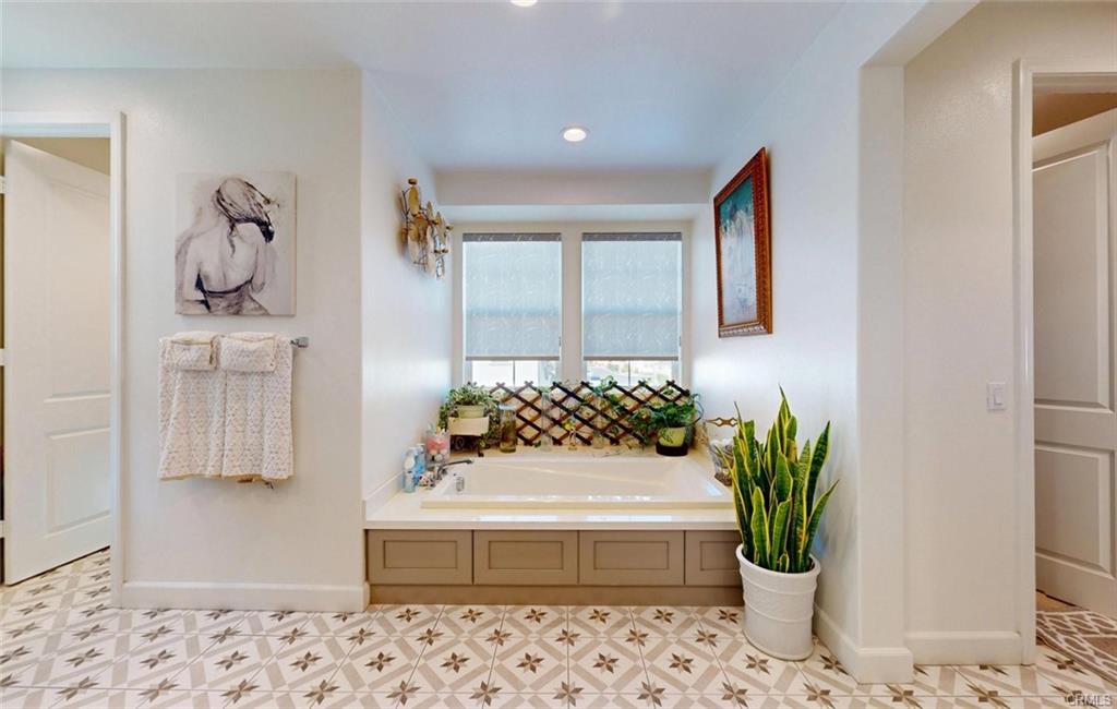 12954 Dahlia St — primary bath soaking tub with designer finishes