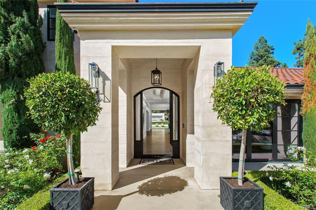 4 Inverness Lane — arched entry with topiaries and stone surround