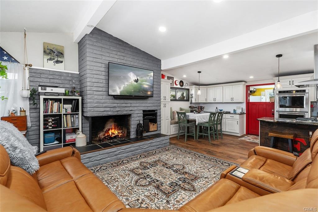 20292 Riverside Dr — open living room with vaulted beamed ceiling and fireplace
