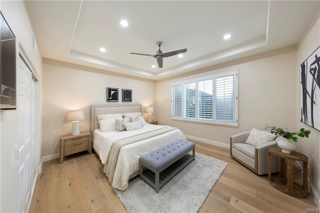 43 Lessay — primary bedroom with ceiling fan and plantation shutters