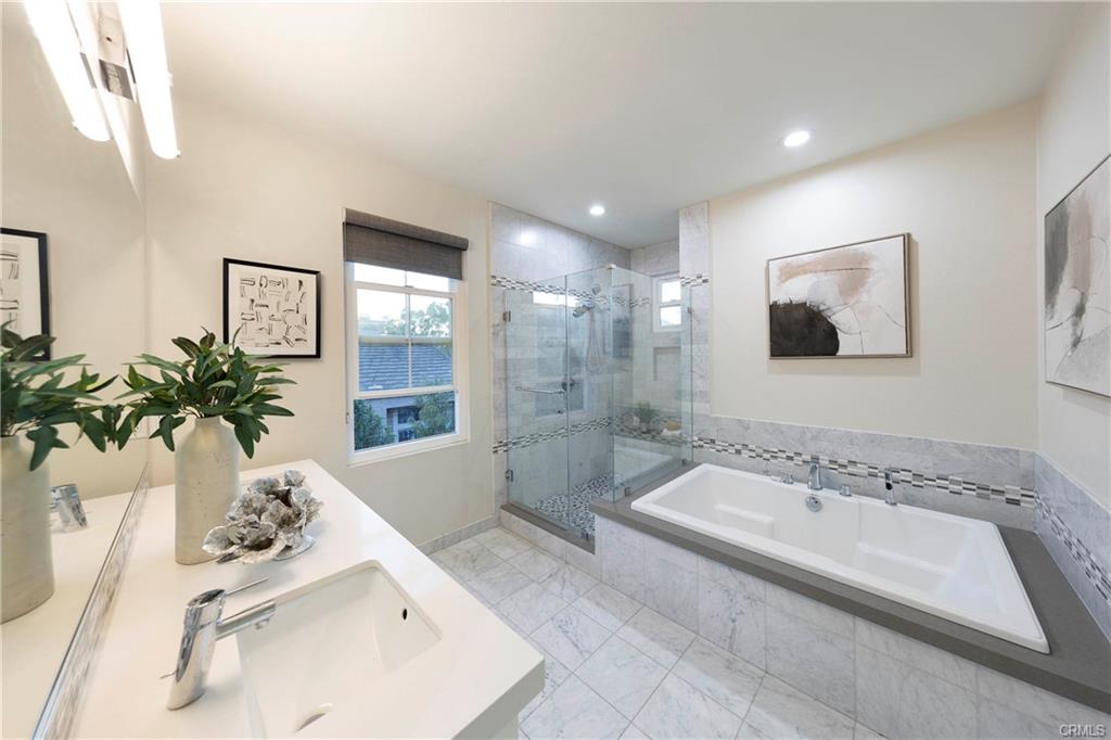 43 Lessay — primary bath with soaking tub, dual vanity, and stone finishes